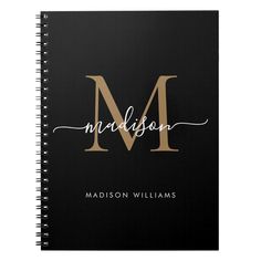 a black and gold monogramed notebook with the letter m in cursive writing