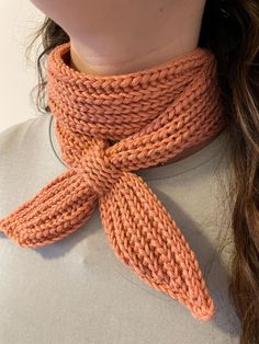 a woman wearing an orange knitted scarf