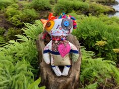 a stuffed animal sitting on top of a tree stump