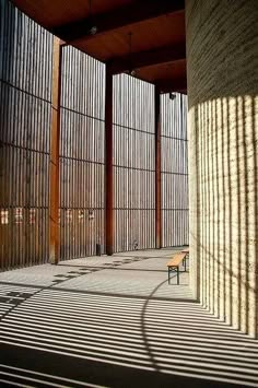 an empty bench sitting in the middle of a building with bars on it's sides