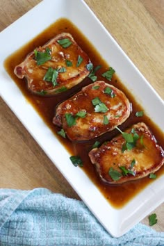 some food on a white plate with sauce and garnished green leafy greens