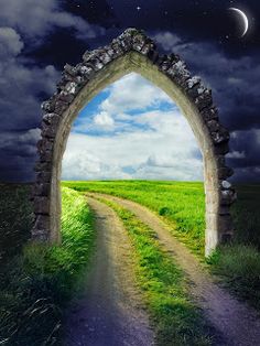 an arch in the middle of a field with a path leading to it under a full moon