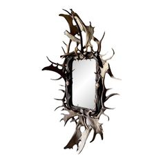 a mirror with antlers on it is hanging from the wall in front of a white background