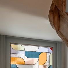 a close up of a stained glass window on a door frame in a room with wood trimming