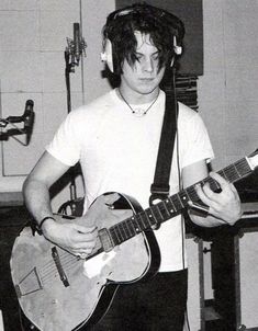 a man with headphones playing an electric guitar