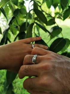 two people holding each other's hands with their wedding rings