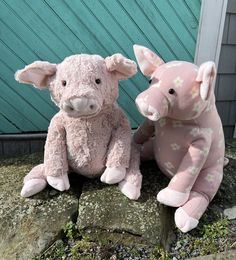 two stuffed animals sitting on top of a stone slab next to a green wall and door