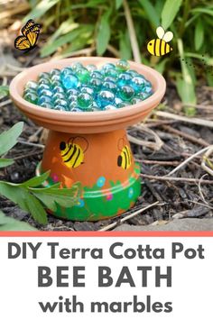 a clay pot filled with blue and yellow marbles sitting on the ground next to grass