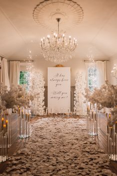 the aisle is decorated with white flowers and candles