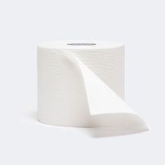 a roll of white toilet paper on a white surface with a shadow from the top