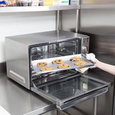 a person taking cookies out of an oven