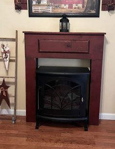 a fire place in the corner of a room with a painting on the wall above it