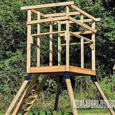 a wooden structure sitting on top of a lush green field