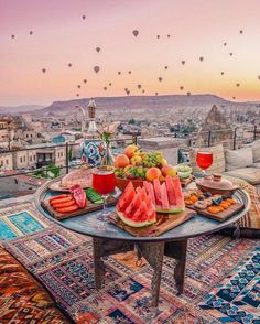 a table topped with watermelon slices on top of a rug