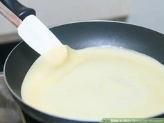 a frying pan filled with cheese being stirred by a spatula