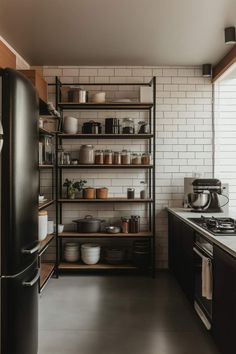 a kitchen with black appliances and shelves filled with pots, pans and other items