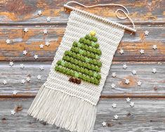 a green christmas tree on a white wall hanging