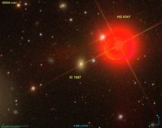 an image of a bright red object in the dark sky with stars and small objects around it