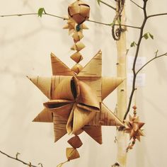 an origami star hanging from a tree branch