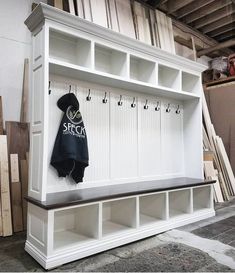 a white bench with coat racks and hooks on it