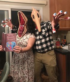 a man and woman wearing masks holding toothbrushes in their hands while standing next to each other