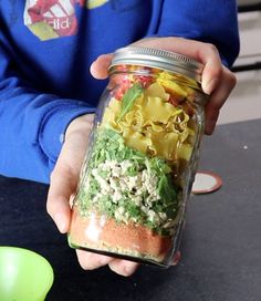 a person holding a jar filled with food