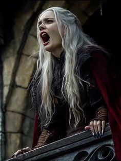 a woman with long white hair wearing a red cape and holding a window sill