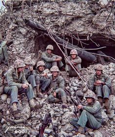 a group of soldiers sitting on top of a pile of rocks next to each other