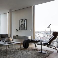 a living room filled with furniture and a large window overlooking the cityscape behind it