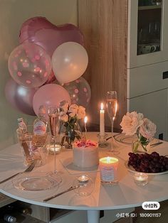 a table topped with lots of balloons and candles