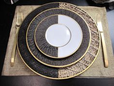 a black and gold place setting on a table