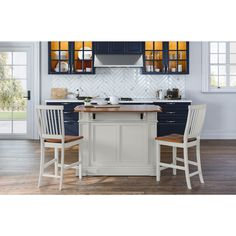 a kitchen island with two chairs next to it in front of a stove and cabinets