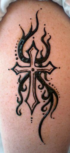 a cross tattoo on the back of a woman's shoulder