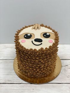 a birthday cake with a hedge on it's face and brown icing, sitting on top of a wooden table