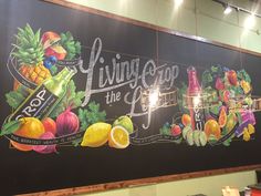 a large sign that is on the side of a building with fruit and beverages painted on it