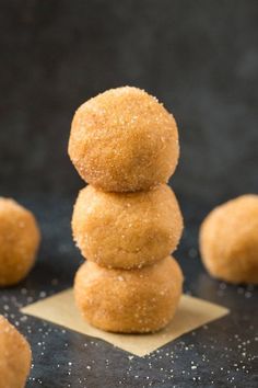 three donuts stacked on top of each other with sugar sprinkles around them