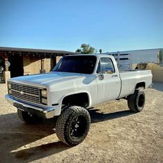 a large white truck parked in the dirt