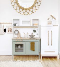 a kitchen with white walls and wooden floors, including a blue cabinet and countertop