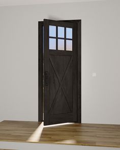 an empty room with a black door and wooden floor