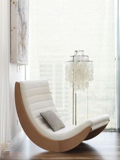 a white chair sitting next to a window in a living room