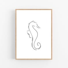 a black and white drawing of a sea horse on a white wall above a wooden frame