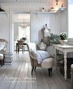 an old fashioned living room with white walls and wood flooring on the wooden floors