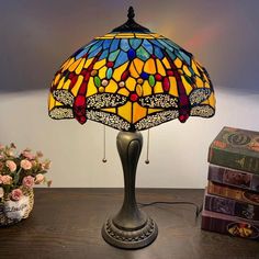 a table lamp sitting on top of a wooden table next to a stack of books