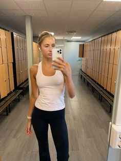 a woman taking a selfie in a locker room