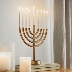 a gold menorah with candles on top of it and a stack of books next to it