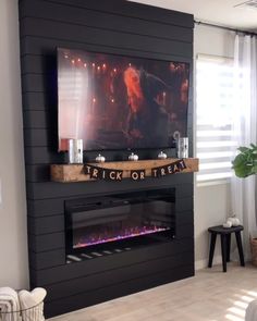 a living room with a large tv mounted on the wall and a fire place in front of it