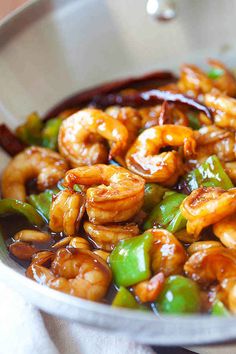 a pan filled with shrimp and peppers on top of a table