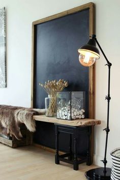 a room with a blackboard and some lights on the wall next to a table