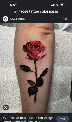 a rose tattoo on the leg with black leaves and red flower in it's center