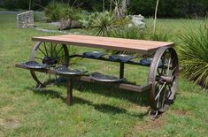 a wooden table sitting on top of a grass covered field next to a garden bench